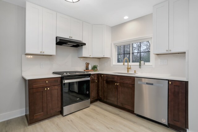 kitchen featuring appliances with stainless steel finishes, light hardwood / wood-style flooring, dark brown cabinets, and sink