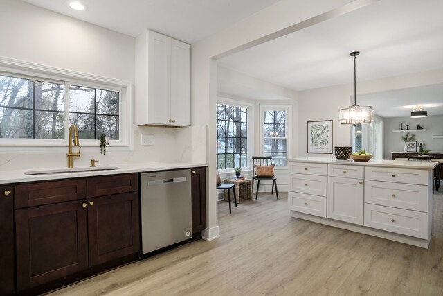 kitchen with stainless steel dishwasher, plenty of natural light, pendant lighting, and sink