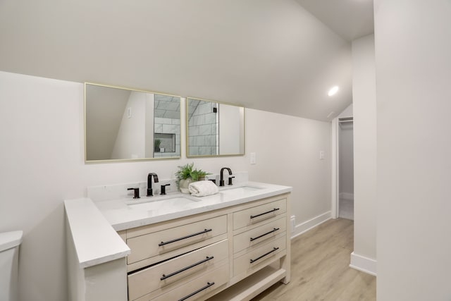 bathroom featuring hardwood / wood-style floors, vanity, toilet, and lofted ceiling