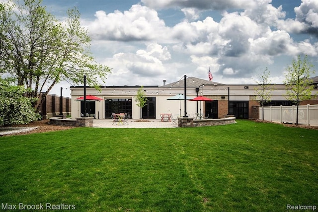 rear view of property featuring a lawn and a patio area