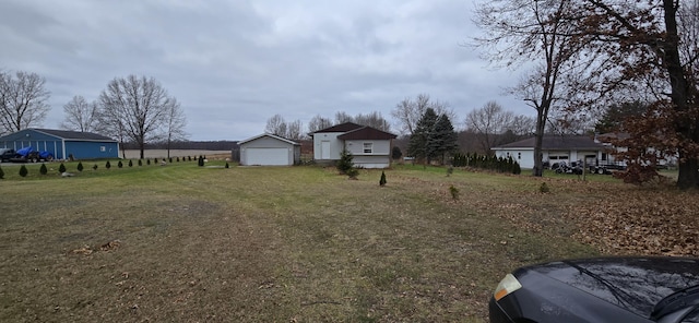 view of yard with a garage and an outbuilding