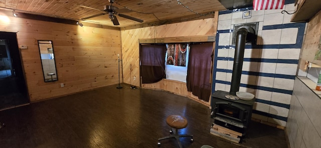 interior space featuring a wood stove, wooden walls, and wood ceiling