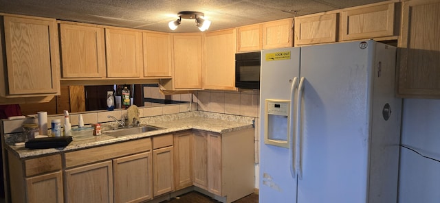 kitchen featuring white refrigerator with ice dispenser, light brown cabinets, a textured ceiling, and sink