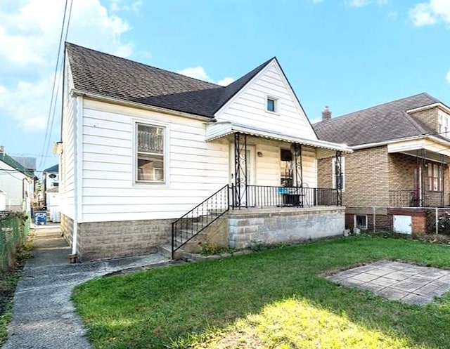 view of front of home with covered porch and a front lawn