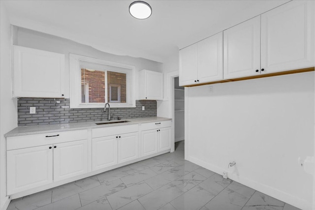 kitchen with white cabinets, backsplash, and sink