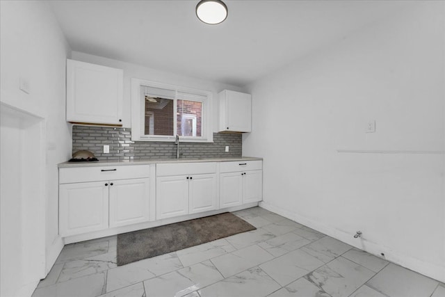 kitchen with tasteful backsplash, sink, and white cabinets