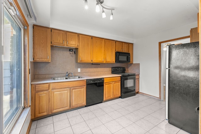 kitchen featuring sink, black appliances, and light tile patterned flooring