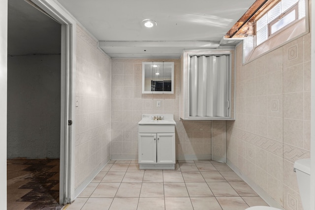 bathroom with vanity, tile walls, tile patterned floors, and toilet