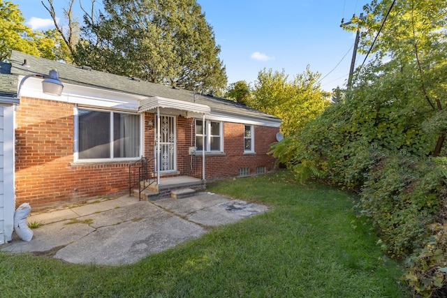 view of front of property with a patio and a front yard