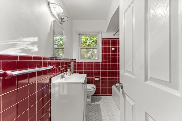 full bathroom with tile patterned floors, bathtub / shower combination, toilet, tile walls, and vanity