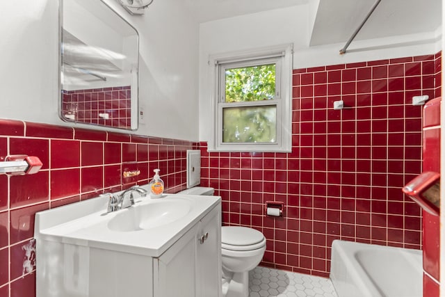 full bathroom featuring tile patterned floors, toilet, shower / bathing tub combination, tile walls, and vanity