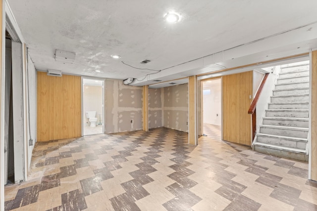 basement featuring wooden walls