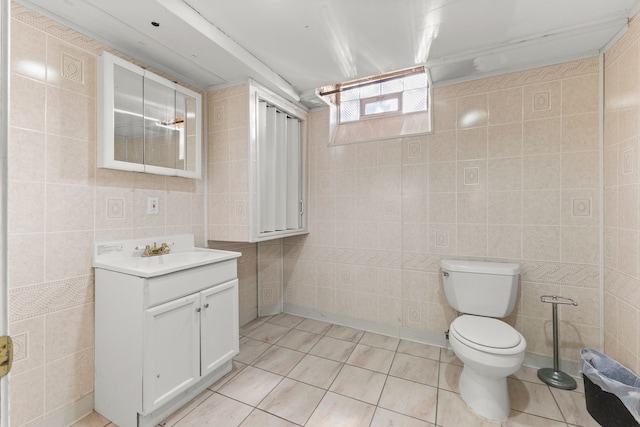 bathroom with tile patterned floors, toilet, tile walls, and vanity