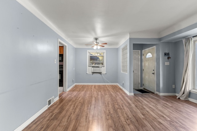 entrance foyer with wood-type flooring, cooling unit, and ceiling fan