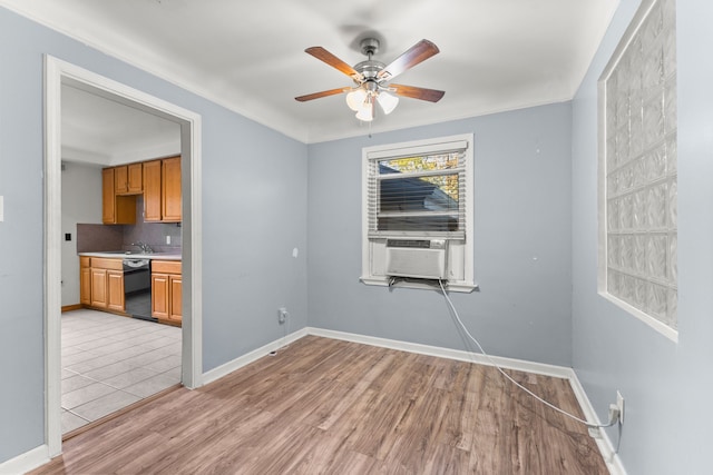 unfurnished room with cooling unit, ceiling fan, sink, and light wood-type flooring