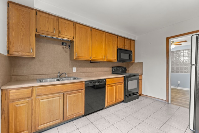 kitchen with light tile patterned flooring, sink, tasteful backsplash, ceiling fan, and black appliances