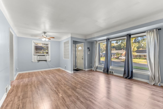 unfurnished room with cooling unit, hardwood / wood-style floors, and ceiling fan