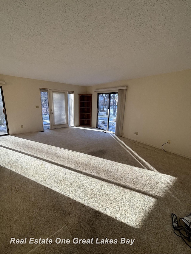 carpeted spare room featuring a textured ceiling