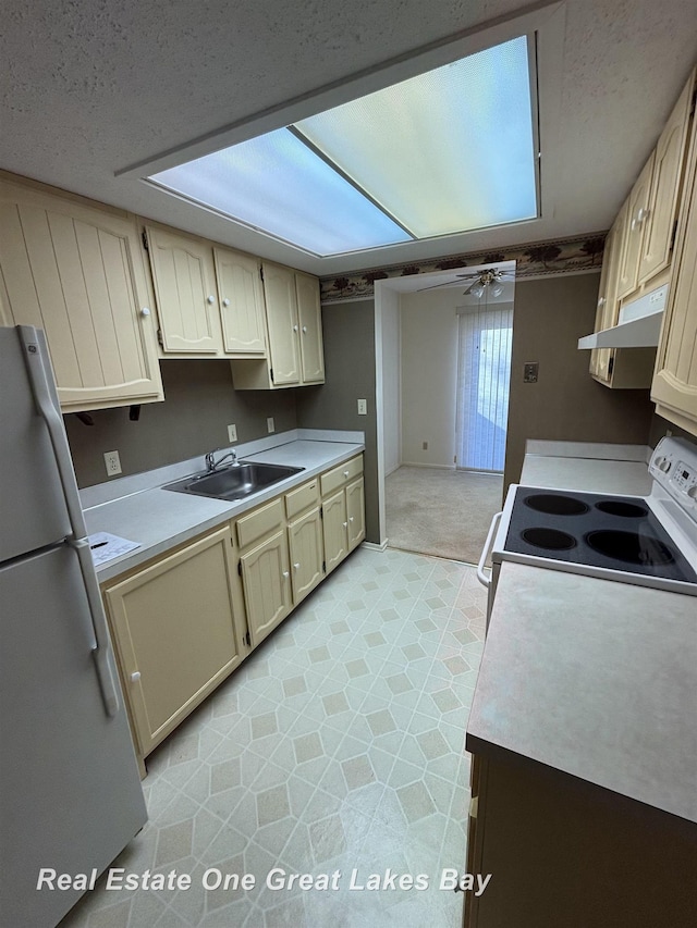 2377 Bay Woods Ct, Bay City, MI 48706 - kitchen featuring white appliances, light countertops, under cabinet range hood, a ceiling fan, and light colored carpet