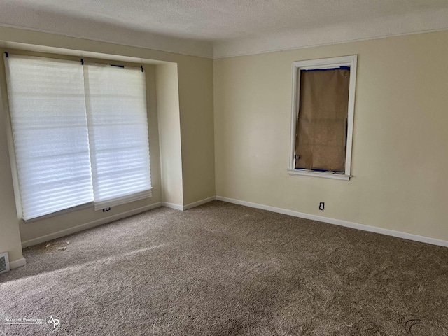 carpeted empty room with a textured ceiling