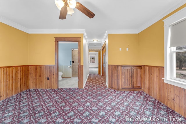 interior space with ceiling fan and ornamental molding