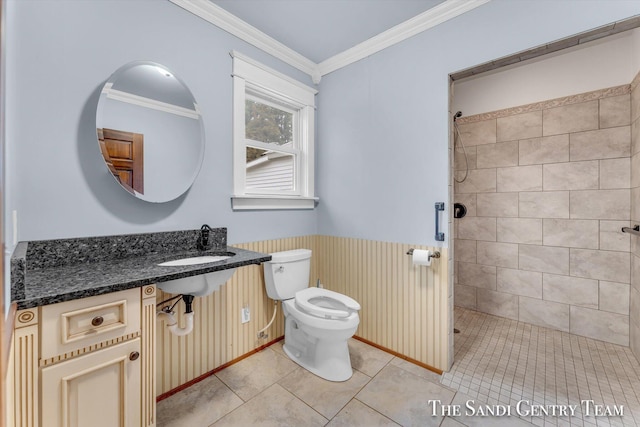 bathroom with crown molding, sink, tile patterned flooring, toilet, and a tile shower