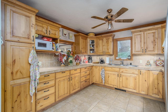 kitchen featuring backsplash, ceiling fan, light tile patterned floors, and sink