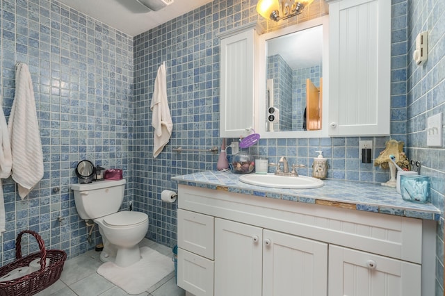 bathroom with vanity, tile patterned floors, toilet, tile walls, and tasteful backsplash