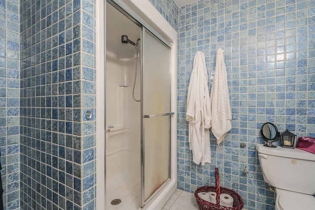 bathroom featuring an enclosed shower, tile patterned flooring, toilet, and tile walls