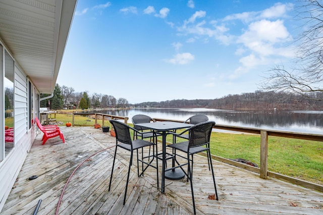 wooden terrace featuring a lawn and a water view