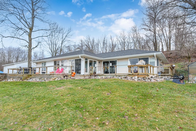 back of property with a yard, a deck, and an outdoor structure