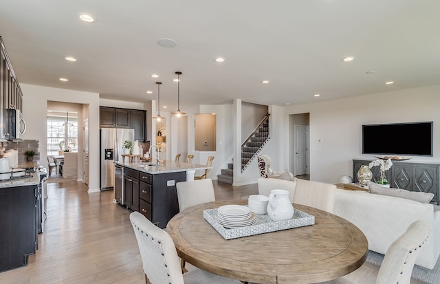 dining space with sink and light hardwood / wood-style floors