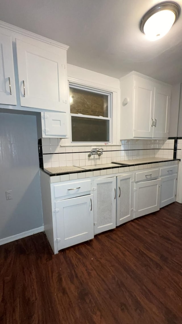 kitchen featuring white cabinets, dark hardwood / wood-style floors, sink, and backsplash