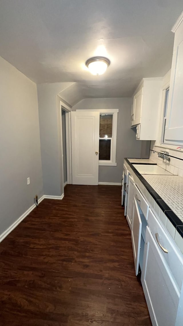 kitchen with white cabinets, sink, dark wood-type flooring, and tasteful backsplash