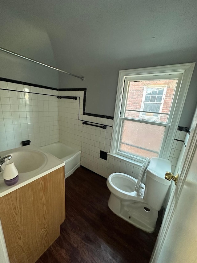 bathroom featuring hardwood / wood-style floors, vanity, toilet, and tile walls