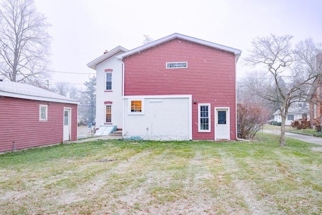 rear view of property featuring a lawn