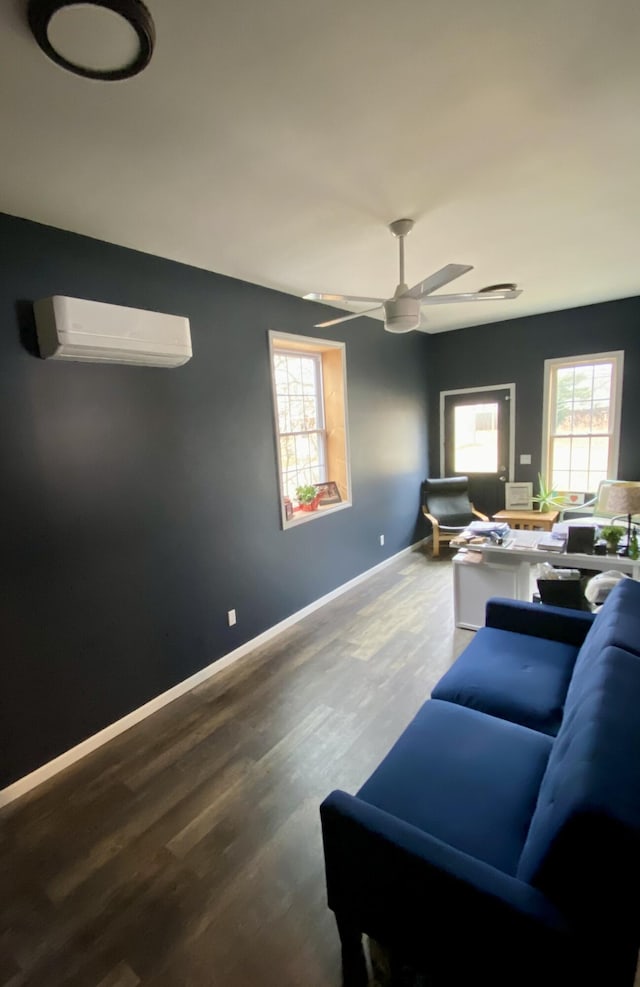 living room with a wall mounted AC, wood finished floors, and a wealth of natural light