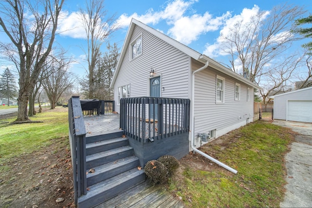 view of front facade with an outbuilding, a garage, a front yard, and a deck