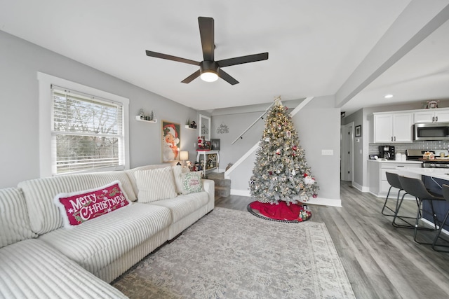 living room featuring ceiling fan and light hardwood / wood-style floors