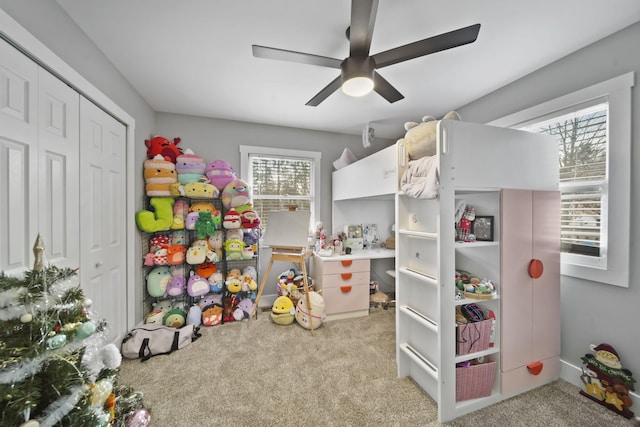 carpeted bedroom with ceiling fan and a closet