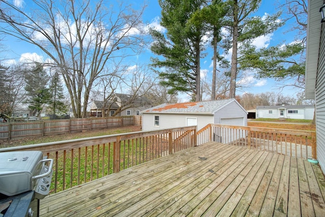 wooden terrace featuring a yard, an outdoor structure, and a garage