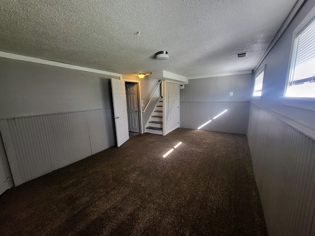 empty room featuring dark colored carpet and a textured ceiling