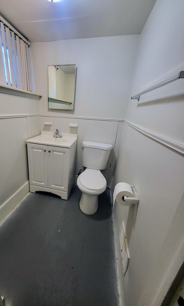 bathroom with vanity, concrete floors, and toilet