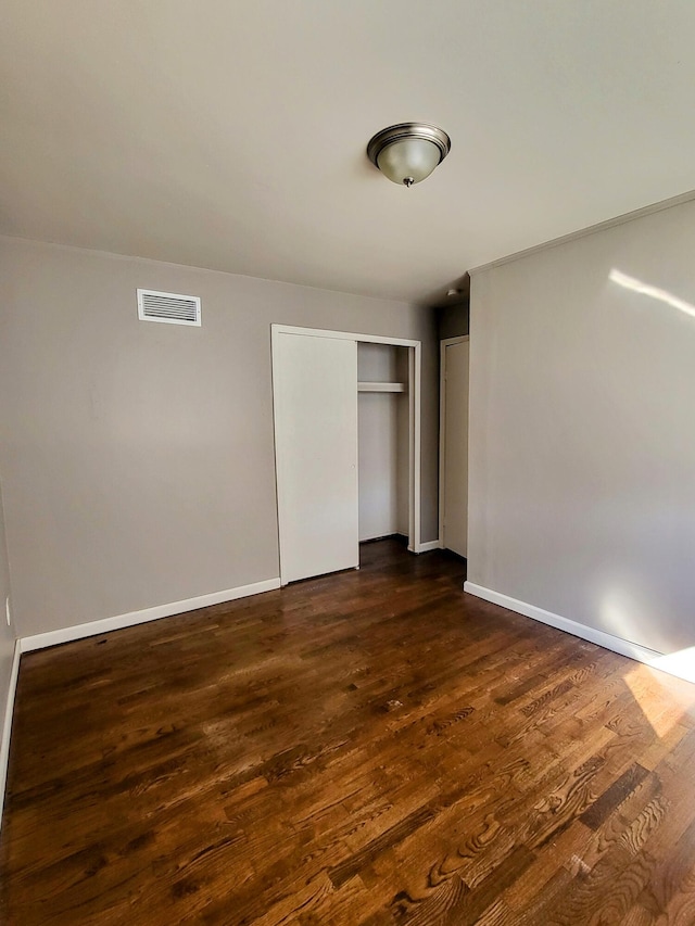 unfurnished bedroom with dark hardwood / wood-style floors