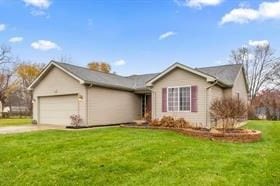 ranch-style house with a garage and a front lawn