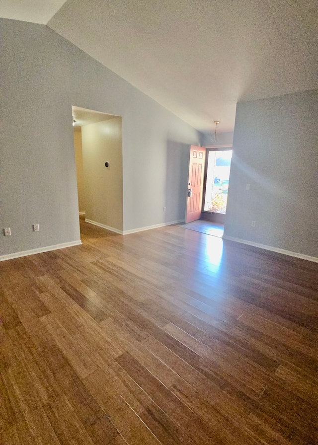 unfurnished room featuring a textured ceiling and vaulted ceiling