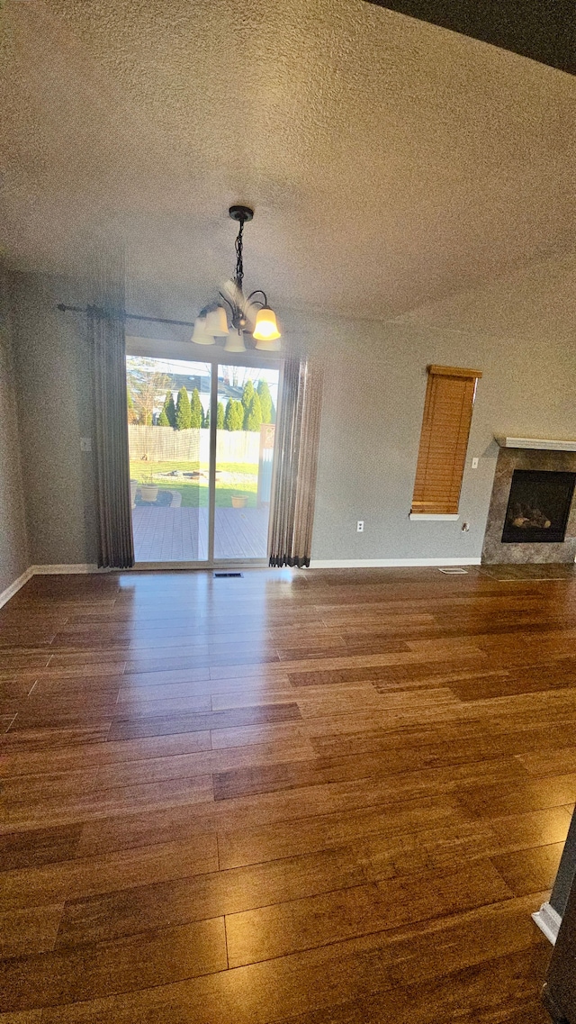 interior space featuring dark hardwood / wood-style flooring, a textured ceiling, and an inviting chandelier