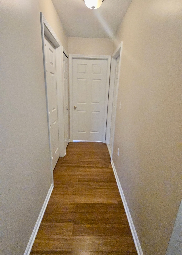 corridor with dark hardwood / wood-style floors