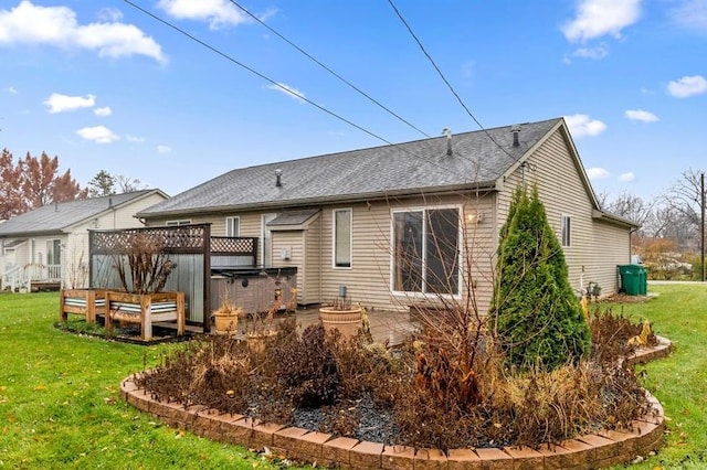 back of house with a lawn and a hot tub