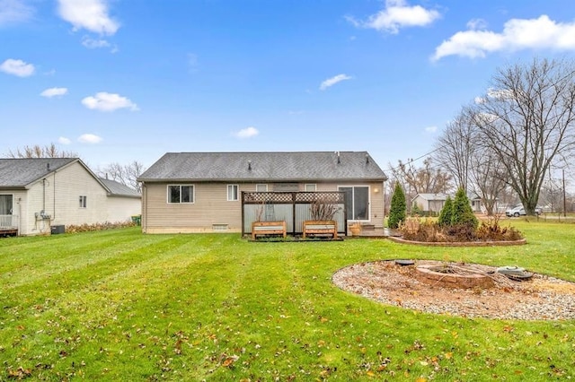 back of house with a deck and a lawn